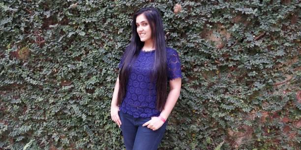 istock Beautiful young woman posing against wall 1138420194