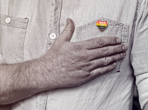 A rainbow flag in the shape of a heart is pinned to the shirt pocket. stock photo