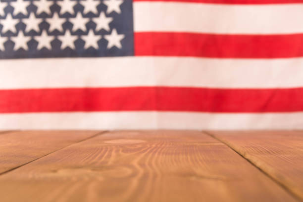 istock Wooden table and American flag in the background. Selective focus. 1138422514