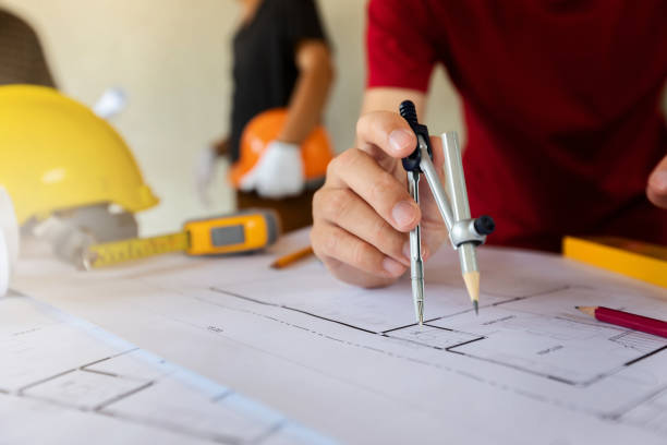 istock An architect or engineer working on blueprint, An architect or engineer uses a divider gauge on the blueprint., architectural concept 1138428796