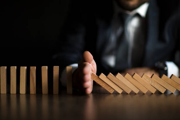 istock Businessman Stop Domino Effect. Risk Management and Insurance Concept 1138429176