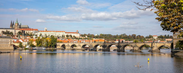 istock Famous Charles Bridge in Prague, Czech Republic under blue sky. Ship in Vltava river, panoramic view, banner, space. 1138429622