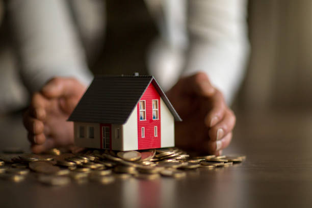istock Real estate investment. House and coins on table. 1138430949