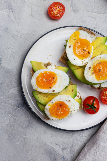 皿にゆで卵とアボカドと穀物パンにサンドイッチをクローズアップ - sandwich breakfast boiled egg close up ストックフォトと画像