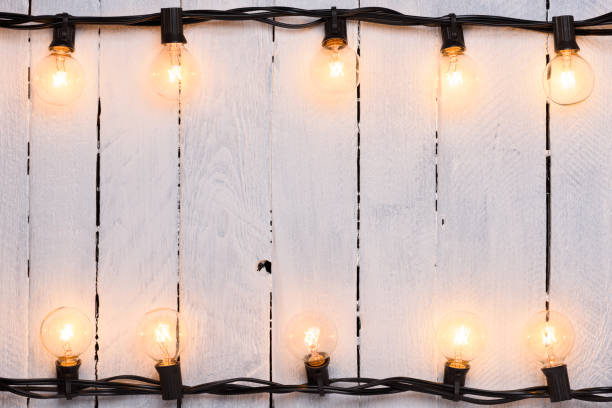 istock Light bulbs garland on old painted wooden wall 1138435312
