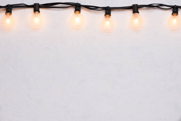 istock Light bulbs retro garland border on white wall 1138435403