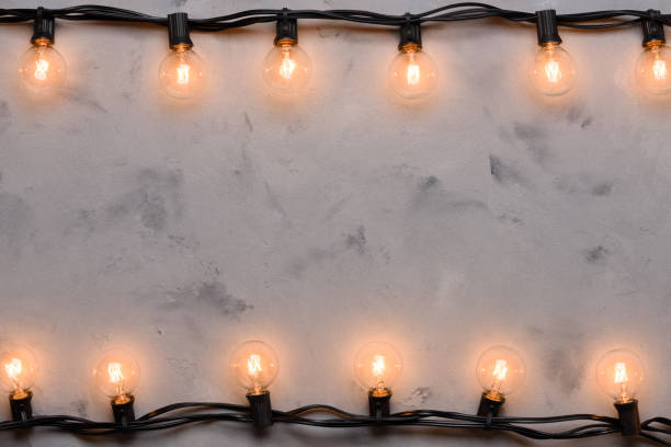 istock Light bulb garland glowing on concrete table background 1138435433