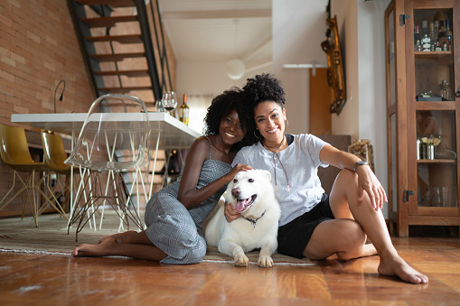 Lesbian Couple or Friends with Berger Blanc Suisse Dog at Home