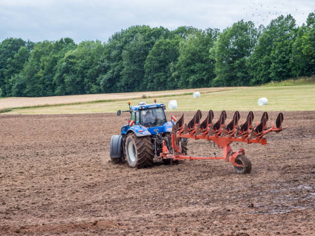 istock Tractor ploughs the field around 1138436495
