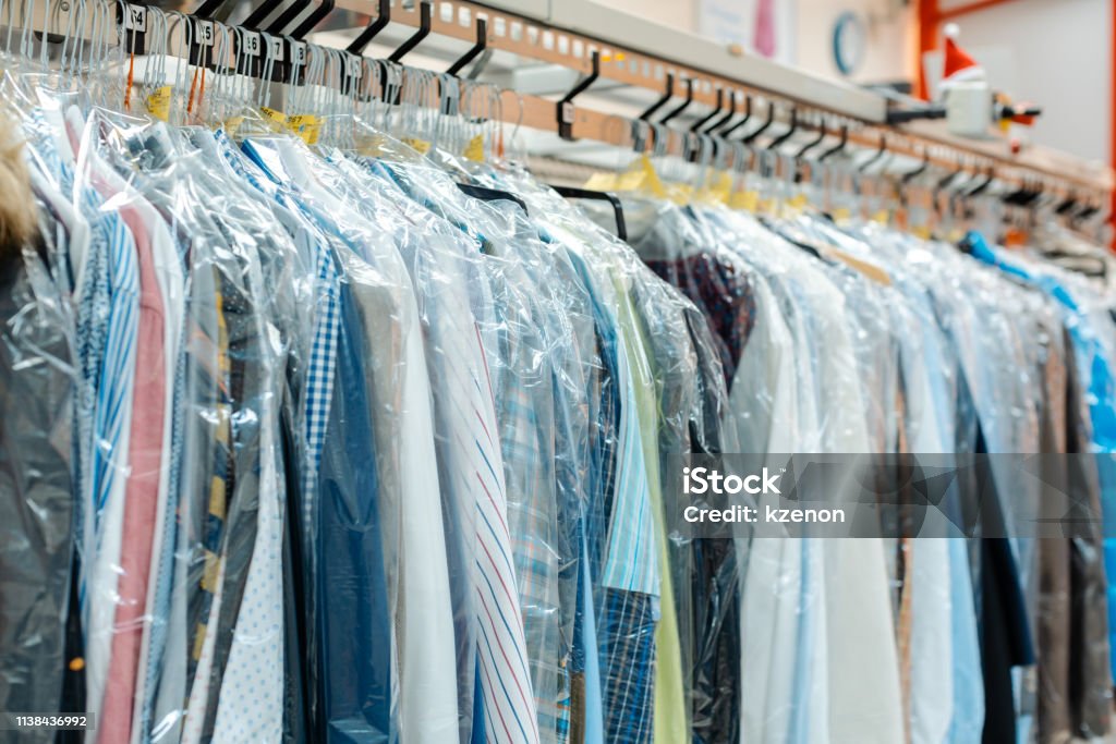 Carousel of clothing waiting for pick-up in dry cleaning shop Carousel of clothing waiting for pick-up by their owners in dry cleaning shop Dry Cleaned Stock Photo