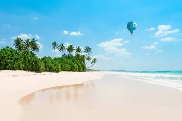 Photo of Untouched tropical beach with air balloon in the sky