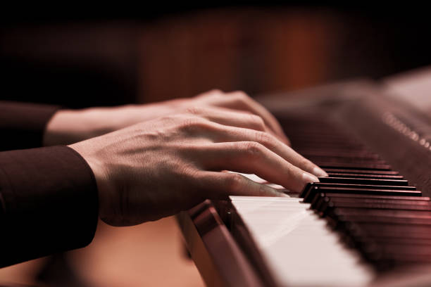 mani di un musicista che suona un sintetizzatore - piano piano key orchestra close up foto e immagini stock