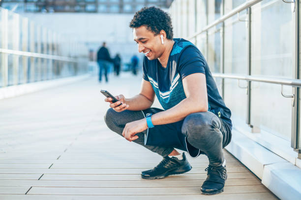istock Smiling athlete with smart phone 1138441415