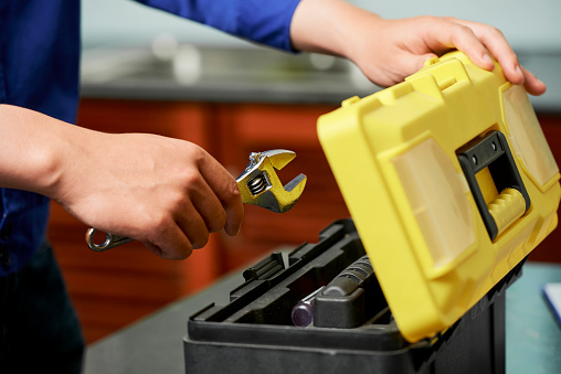 Close-up of repairman opens toolbox and puts his tools in it after his work