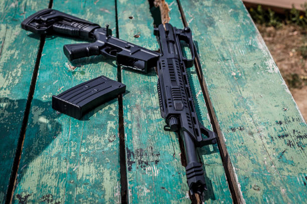 istock Black automatic shotgun on an old green wooden table 1138443179
