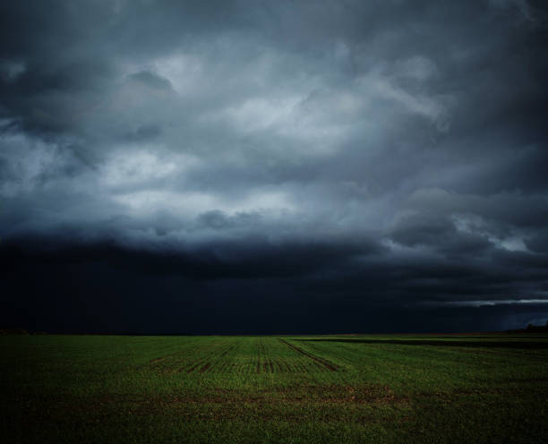 istock Green field under dark thunderstorm sky 1138443195