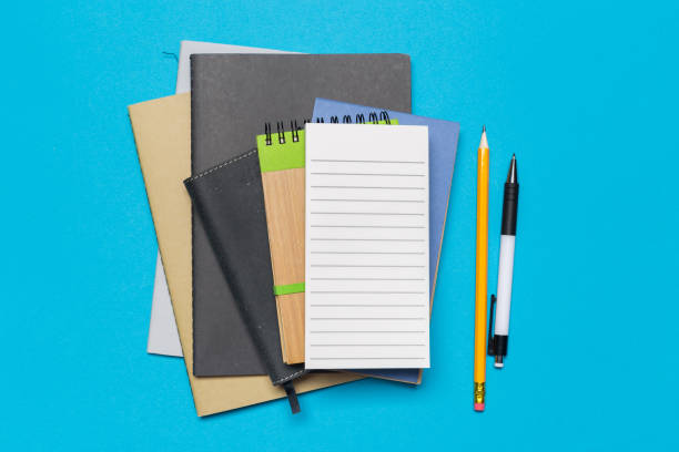 istock Blank paper notebook on blue background.Office desk table concept. 1138444428
