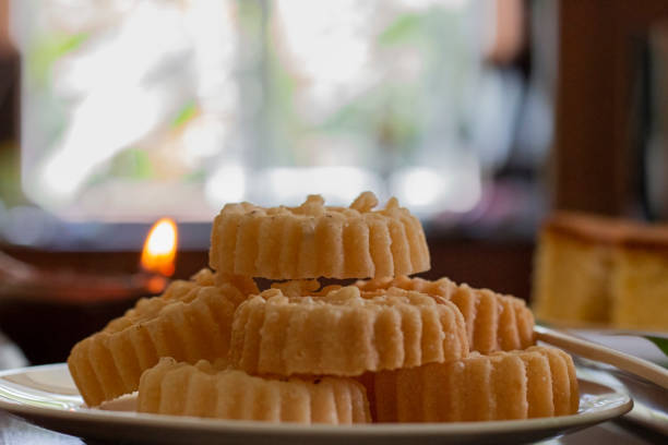 Kokis on a plate with a lit oil lamp in the background - Side view A Sri Lankan Sinhala and Tamil New Year Festive Food stock photo