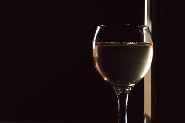 istock elegant wine bottles and wine glass in a black background 1138444503