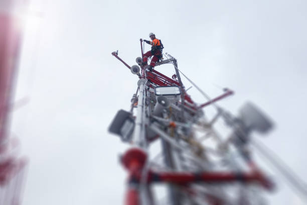 rope access technician climbing on the tower - antenna with hooks and looking down - high frequencies imagens e fotografias de stock