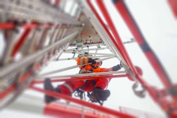 istock Rope access technician climbing on the tower - antenna with hooks and looking down 1138444633