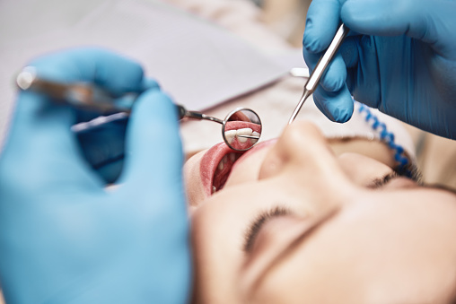 Medicina avanzada, atención de confianza. Una mujer atractiva en el consultorio dental. Dentista examinando los dientes del paciente en la clínica. photo