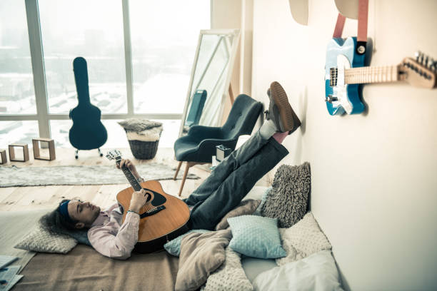 istock Melancholic young artist leaning on clear wall with his legs 1138449280