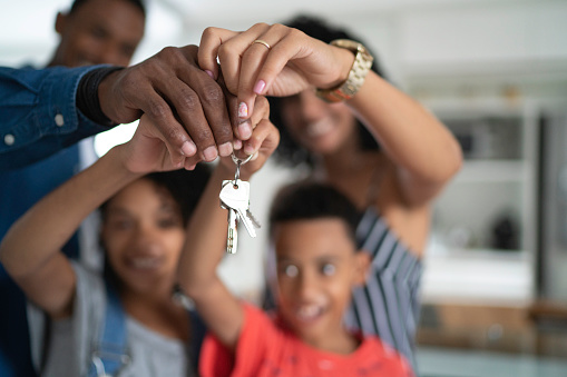 Familia Latina sosteniendo las llaves de su nueva casa photo