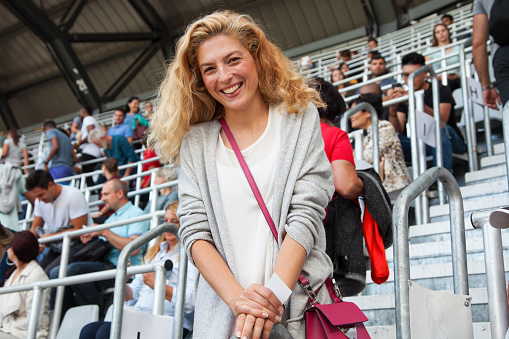 Young woman coming to a football match. Smiling portrait.
