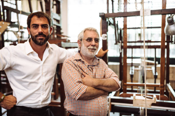 istock senior and young owner in a factory 1138456632