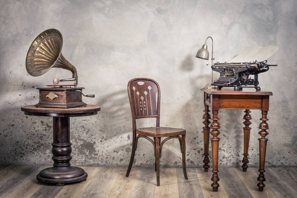 vintage loft zimmer mit alter schreibmaschine und lampe auf holztisch, antikem stuhl und klassischem grammophon mit messinghorn frontschallrückgang mit schatten. retro-stil gefiltert foto - typewriter storytelling fairy tale book stock-fotos und bilder