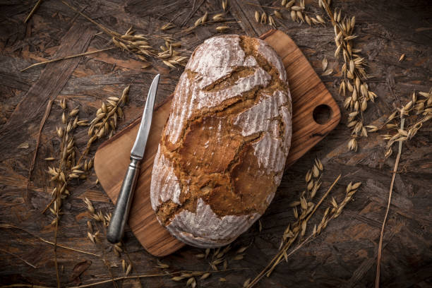 istock Wholegrain bread with knife on cutting board and wooden table 1138462032