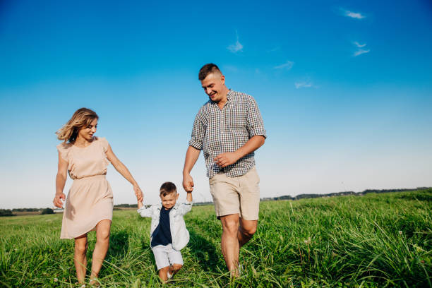 istock Happy boy with parents running in park. Summertime 1138463110