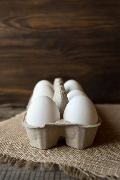 istock Raw eggs in egg box on wooden background. 1138463341