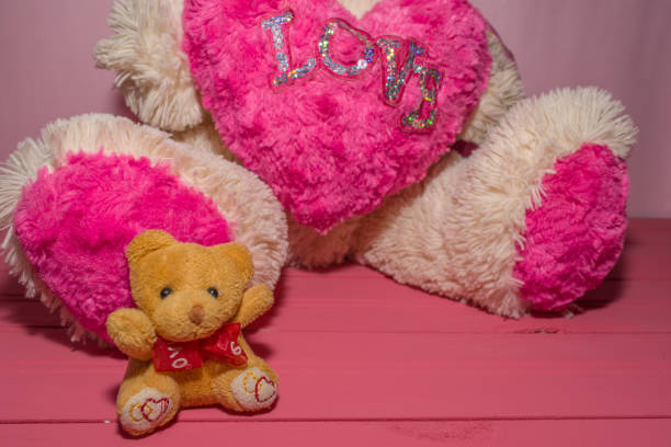 istock small yellow teddy bear on pink wooden background 1138463532