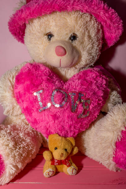 istock small yellow teddy bear on pink wooden background 1138463542