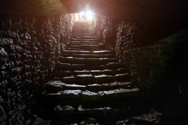 Underground passage under old medieval fortress. Old stone stairs to exit of tunnel.