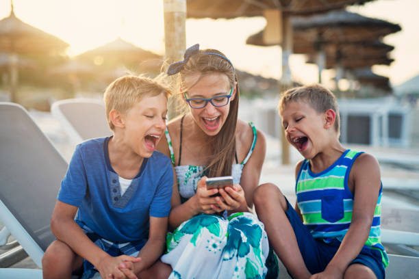 istock Kids viewing vacations photos on beach 1138468424