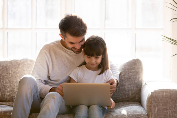 istock Father spending free time with lovely daughter using laptop 1138470032