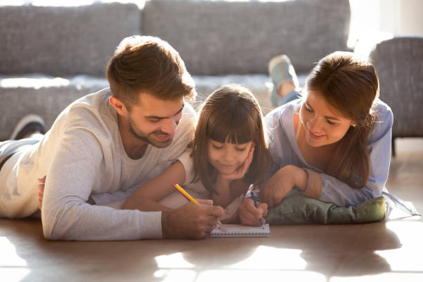 istock Couple and daughter lying on warm floor and drawing 1138470048
