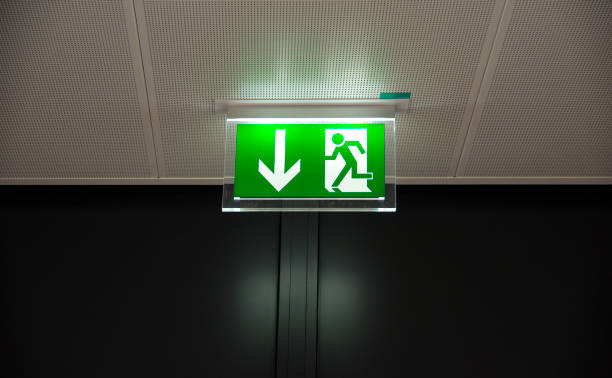 istock Green emergency escape sign on the ceiling 1138470767