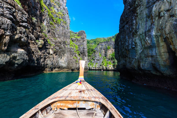 istock Wang Long Bay with crystal turquoise water, Tropical island Koh Phi Phi Don, Krabi Province, Thailand - Long boat in beautiful lagoon with rocks covered with a plants 1138472542