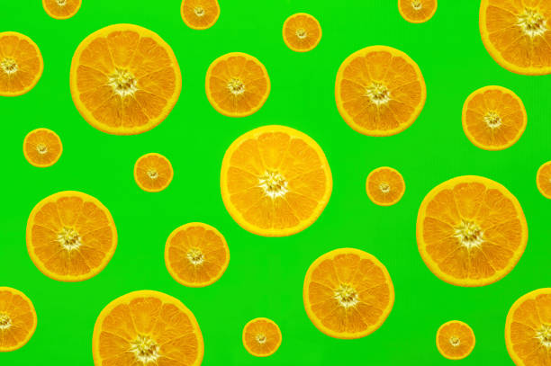 istock Many orange slices, half sliced oranges of different sizes against a strong colored background in green 1138476146