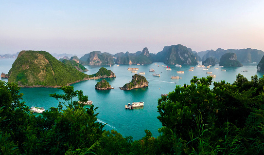 A photo of a Ha Long Bay with dozens of boats during sunset, Vietnam