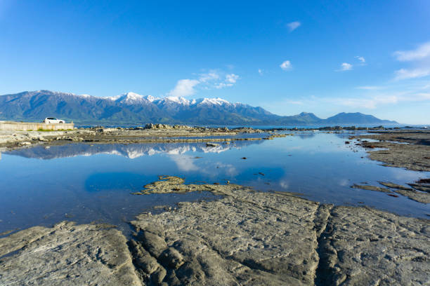 istock Snow-capped Kaikoura Mountains reflected in calm rockpool 1138479995