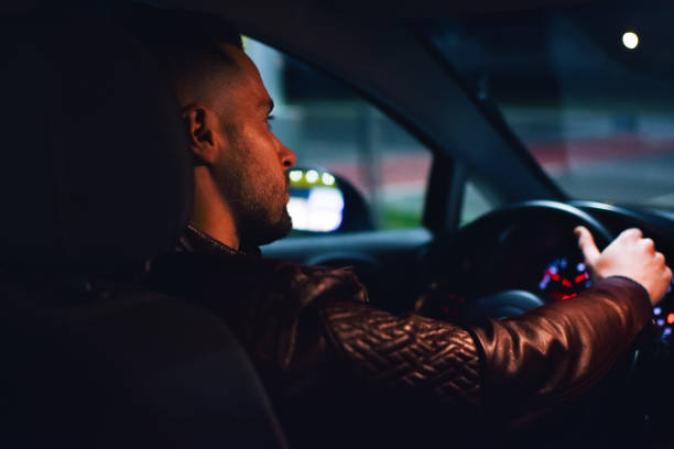 istock Man driving a car at night 1138482304