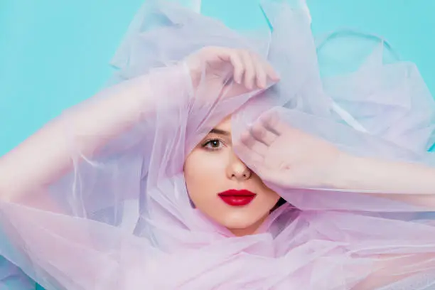 Photo of Young woman with pink tulle on blue background