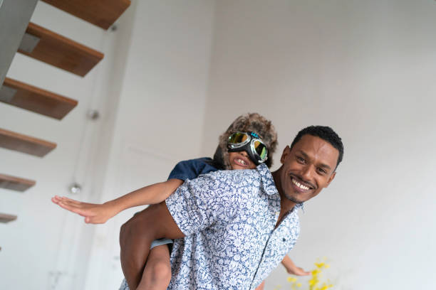istock Boy with pilot glasses play fly with his dad at home 1138489092