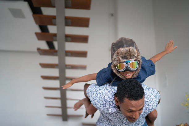 istock Boy with pilot glasses play fly with his dad at home 1138489095