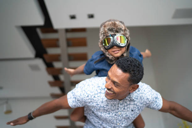 istock Boy with pilot glasses play fly with his dad at home 1138489161